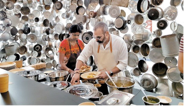 Indian artist Subodh Gupta cooks cuisine from his home country inside an installation he created using Indian pots and pans at Maison de L’Architecture in Poitiers, France. MOON SO-YOUNG
